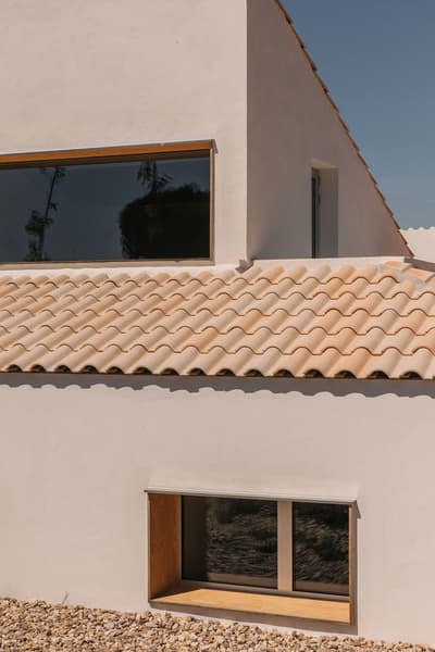 Architectural project - natural stone, exterior facade, architectural roofline, Mediterranean influences, retreat home, tile, countryside vibe, residential exterior, warm minimalism, terracotta roof, villa, modern villa, minimalist villa, tile roof, modern Mediterranean, contemporary rustic, stone details, minimal exterior, natural materials, outdoor space, natural light, passive design, sustainable design, warm tones, daylight, exterior design, rustic charm, leisure space, serene atmosphere, tranquil setting, earth tones, eco home, modern facade, clean lines, white walls, energy efficient, stone, plaster, Mediterranean style, terracotta, warm beige, rural setting, landscape design, vacation home, plaster walls, earthy textures, simple architecture, garden space, light beige