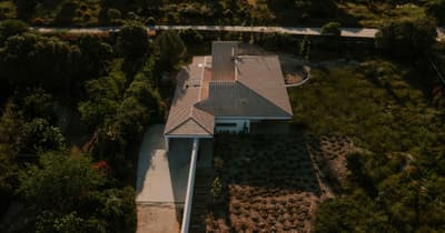 Architectural project - tiled roof, grey roof, roof tiles, spacious land, aerial house, countryside villa, large garden, outdoor garden, single-story house, driveway, entrance path, backyard garden, spacious property, garden oasis, farmhouse vibes, green tones, concrete path, relaxation space, natural materials, outdoor living, sustainable design, outdoor area, grey, landscape architecture, beige, daylight optimization, eco friendly, simple design, natural textures, low carbon, passive house, nature view, scenic view, green landscape, white, panoramic view, sloped roof, nature retreat, rural setting, landscape design, garden landscape, minimalist exterior, residential home, secluded home, private residence, modern home, contemporary house, garden path, home garden, cozy home, modern rural, suburban home, green space, green roof, aerial view, natural surroundings, rural retreat