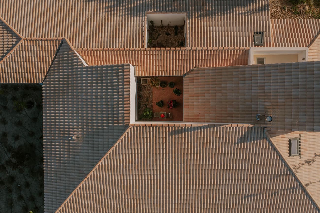Architectural project - rooftop garden, roof tiles, courtyard design, terracotta roof, roof pattern, home exterior, beige roof, architectural roofing, eco friendly roof, insulating roof, integrated garden, residential roof, wall openings, ventilation strategy, natural materials, outdoor space, passive design, sustainable design, warm tones, neutral tones, beige, roof design, building design, natural textures, thermal mass, biophilic design, natural ventilation, landscape integration, modern architecture, energy efficient, rustic style, earthy tones, clay, terracotta, garden view, traditional roofing, Mediterranean vibe, textured roof, courtyard, aerial view, sustainable living, neutral, clay tiles