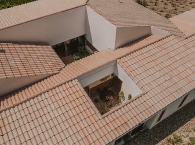 Architectural project - minimalist house, tiled roof, terracotta roof, geometric forms, roof pattern, open courtyard, central courtyard, angled roof, plaster facade, plaster exterior, linear forms, flat layout, light earth tones, beige tiles, layered roof, protective roof, modern roof, shaded areas, house layout, architectural layout, minimal design, natural materials, outdoor space, passive design, warm tones, eco design, sustainable architecture, neutral tones, geometric design, natural ventilation, contemporary home, white facade, modern architecture, earthy tones, pitched roof, residential design, gable roof, white exterior, horizontal design, courtyard, exterior space, clay tiles, ceramic tiles, garden space, suburban house
