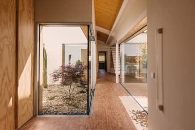 Architectural project - natural elements, indoor garden, terracotta tiles, modern corridor, atrium garden, Japanese maple, brick flooring, interior garden, zen vibe, minimal design, tranquil space, wood, timber, natural light, sustainable design, glass, warm tones, green, exposed beams, daylight, beige, brown, light wood, eco friendly, Scandinavian influence, honey wood, meditative space, minimalist style, neutral palette, biophilic design, large windows, timber cladding, white, Nordic design, inviting home, modern architecture, timber ceiling, warm ambiance, airy space, open layout, open plan, glass walls, earthy tones, terracotta, brick, cozy atmosphere, residential design, garden view, passive solar, seamless indoor outdoor, courtyard, smooth finish, wood panel, spacious feel