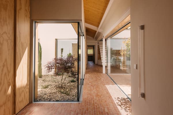 Architectural project - natural elements, indoor garden, terracotta tiles, modern corridor, atrium garden, Japanese maple, brick flooring, interior garden, zen vibe, minimal design, tranquil space, wood, timber, natural light, sustainable design, glass, warm tones, green, exposed beams, daylight, beige, brown, light wood, eco friendly, Scandinavian influence, honey wood, meditative space, minimalist style, neutral palette, biophilic design, large windows, timber cladding, white, Nordic design, inviting home, modern architecture, timber ceiling, warm ambiance, airy space, open layout, open plan, glass walls, earthy tones, terracotta, brick, cozy atmosphere, residential design, garden view, passive solar, seamless indoor outdoor, courtyard, smooth finish, wood panel, spacious feel