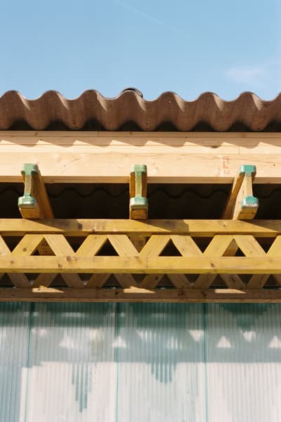 Architectural project - minimal design, natural materials, architectural detail, natural light, sustainable design, warm tones, eco design, green building, exposed structure, corrugated roof, timber structure, exposed beams, daylight, wavy roof, roof detail, light wood, eco friendly, rustic roof, wooden beams, sunlight, farmhouse style, rustic detail, outdoor structure, exterior detail, timber construction, rural architecture, simple design, rustic vibe, honey wood, wood beams, timber beams, outdoor, facade detail, contemporary touch, rustic modern, vernacular architecture, natural textures, weathered wood, organic design, rustic charm, traditional building, wooden detail, lattice structure, architectural texture