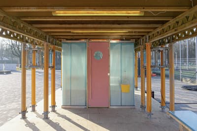 Architectural project - circular window, pink, timber, steel, metal, outdoor space, natural light, yellow, modular design, eco design, exposed structure, sustainable architecture, neutral tones, building framework, construction site, steel beams, modern construction, open frame, daylight, plywood, construction materials, brown, exposed trusses, structural design, plywood flooring, steel columns, industrial elements, temporary building, panel wall, corrugated panels, pink door, unfinished structure, industrial style, minimalist construction, architectural framework, low carbon design, engineered wood, timber supports, metal connections, multifunctional space, open design, light blue panels, innovative building, structural exploration, functional design, daylight optimization, yellow bucket, site equipment, modern framing, sustainable practices, blue