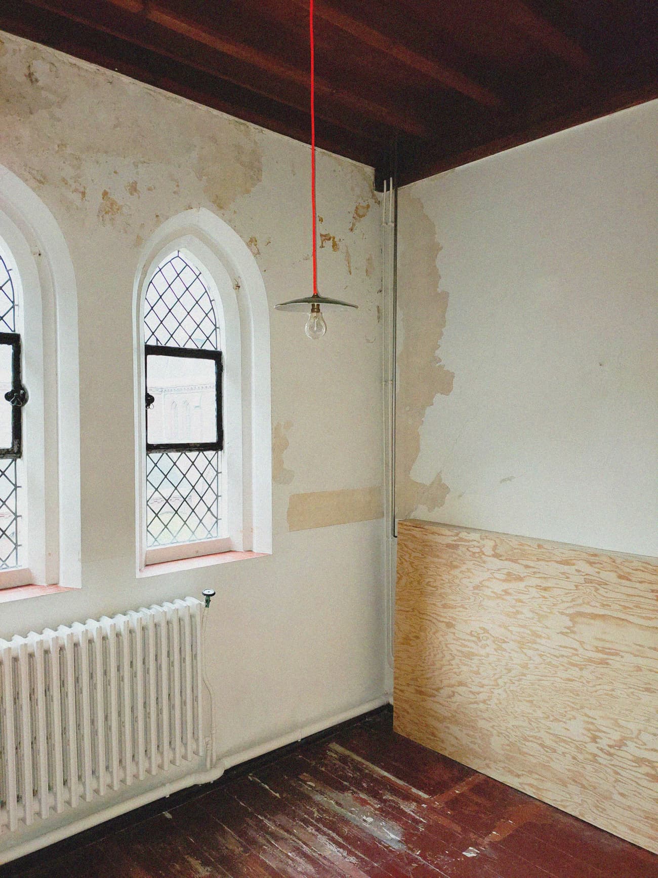 Architectural project - loft style, rustic elegance, rustic interior, vintage vibe, interior window, bohemian touch, historical charm, plywood panel, arched window, renovation project, moody atmosphere, historic renovation, architectural detail, wood, raw materials, metal, natural light, eclectic style, reclaimed materials, natural tones, daylight, rustic charm, industrial touch, wooden floor, white, cozy vibe, textured wall, plaster wall, plaster, minimalist decor, cozy corner, traditional touch, warm lighting, unique design, dark wood, artistic space, creative corner, red