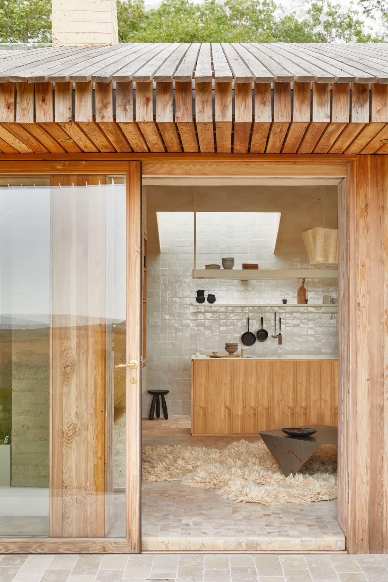 Architectural project - cozy interior, natural materials, eco-friendly design, wood, timber, relaxed vibe, natural light, passive design, glass, warm tones, daylight, timber ceiling, beige, wood facade, timber facade, light wood, honey wood, rustic charm, Scandinavian style, neutral palette, glass doors, soft textures, modern rustic, sustainable home, clean lines, indoor outdoor, white, Nordic design, beige tones, open plan, inviting space, earthy tones, warm atmosphere, clay, terracotta, minimalist kitchen, compact kitchen, sliding doors, wood ceiling, open space, small kitchen, minimal decor, low carbon building, natural insulation, rustic kitchen, terracotta floor, clay tiles, white tiles, shag rug, terrace access, tactile surfaces, handcrafted elements, wooden cabinetry, neutral shades, farm style