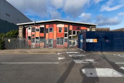 Architectural project - urban building, mixed use, window grid, metal cladding, steel elements, colorful facade, industrial facade, red exterior, metal fence, commercial facade, industrial area, warehouse style, factory building, angular roof, modern industrial, exterior structure, commercial zone, street scene, angular facade, industrial office, colorful building, red walls, exterior contrast, street crossing, urban layout, utilitarian style, steel, glass, city environment, grey, industrial vibe, concrete, functional design, blue, urban design, geometric design, corrugated metal, urban architecture, public building, architectural contrast, street view, red