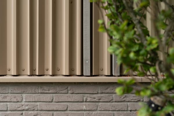 Architectural project - beige facade, vertical lines, metal cladding, light grey, steel cladding, exterior facade, metal texture, industrial facade, low maintenance, industrial look, eco friendly facade, minimal design, architectural detail, steel, metal, neutral tones, beige, exterior design, building facade, corrugated panels, minimalist architecture, contemporary design, urban design, construction detail, building materials, biophilic design, modern facade, modern architecture, greenery, visual interest, facade texture, functional facade, vertical panels, urban facade