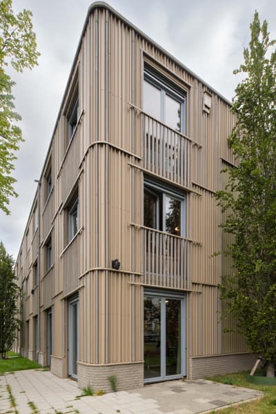 Architectural project - urban greenery, vertical lines, steel cladding, ribbed texture, landscaping, community living, minimalist, architectural design, eco-friendly design, steel, metal, outdoor space, green building, sustainable architecture, grey, neutral tones, urban development, city architecture, beige, daylight optimization, contemporary design, sleek lines, minimalist style, urban design, modern, low carbon, earth tones, natural palette, sustainable home, passive house, modern facade, large windows, energy efficient, greenery, garden view, residential building, green space, environmentally conscious, apartment building, smooth finish, exterior cladding, residential facade, urban living, city residence
