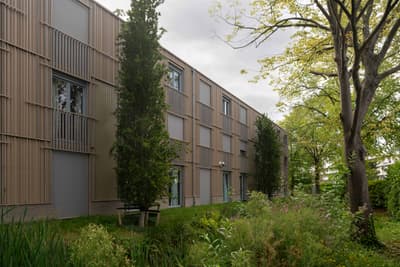 Architectural project - urban greenery, urban residential, wooden details, functional aesthetic, urban habitat, nature blending, building exterior, natural materials, sustainable materials, modular design, green building, contemporary style, sustainable architecture, wood facade, minimalist facade, light wood, low carbon design, daylight optimization, modern design, natural textures, architectural texture, neutral palette, eco materials, outdoor seating, tranquil setting, ecological design, biophilic design, passive house, landscape integration, clean lines, timber cladding, energy efficient, earthy tones, environmental design, exterior view, garden view, vertical cladding, facade rhythm, green space, natural look, residential facade, eco facade, outdoor greenery, modern residential
