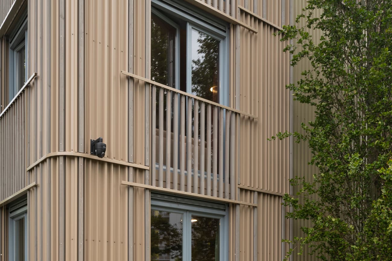 Architectural project - modern building, linear design, facade depth, urban dwelling, vertical lines, green facade, ribbed cladding, exterior architecture, rhythmic facade, natural materials, architectural detail, wood, timber, city living, warm tones, eco design, green building, innovative design, neutral tones, beige, timber facade, exterior design, minimalist facade, light wood, facade detail, light brown, biophilic design, passive house, natural ventilation, energy efficient, greenery, wooden facade, residential building, sustainable facade, contemporary facade, urban nature, vertical cladding, facade texture, architectural rhythm, apartment building, eco facade