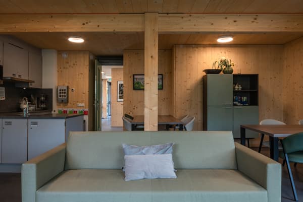 Architectural project - wood wall, cozy living, warm interior, intimate space, natural materials, wood, timber, raw materials, natural light, multifunctional area, neutral tones, exposed beams, functional space, daylight, wooden ceiling, concrete, light wood, compact space, farmhouse style, rustic modern, calming space, relaxed atmosphere, structural wood, modern rustic, eco home, sustainable home, modular home, Nordic design, cozy vibe, inviting home, timber ceiling, green living, timber interior, open layout, open plan, earthy tones, Scandinavian design, bright interior, minimal decor, timber wall, clean design, simple furniture, natural finishes, living space, family area, home living, wood interior
