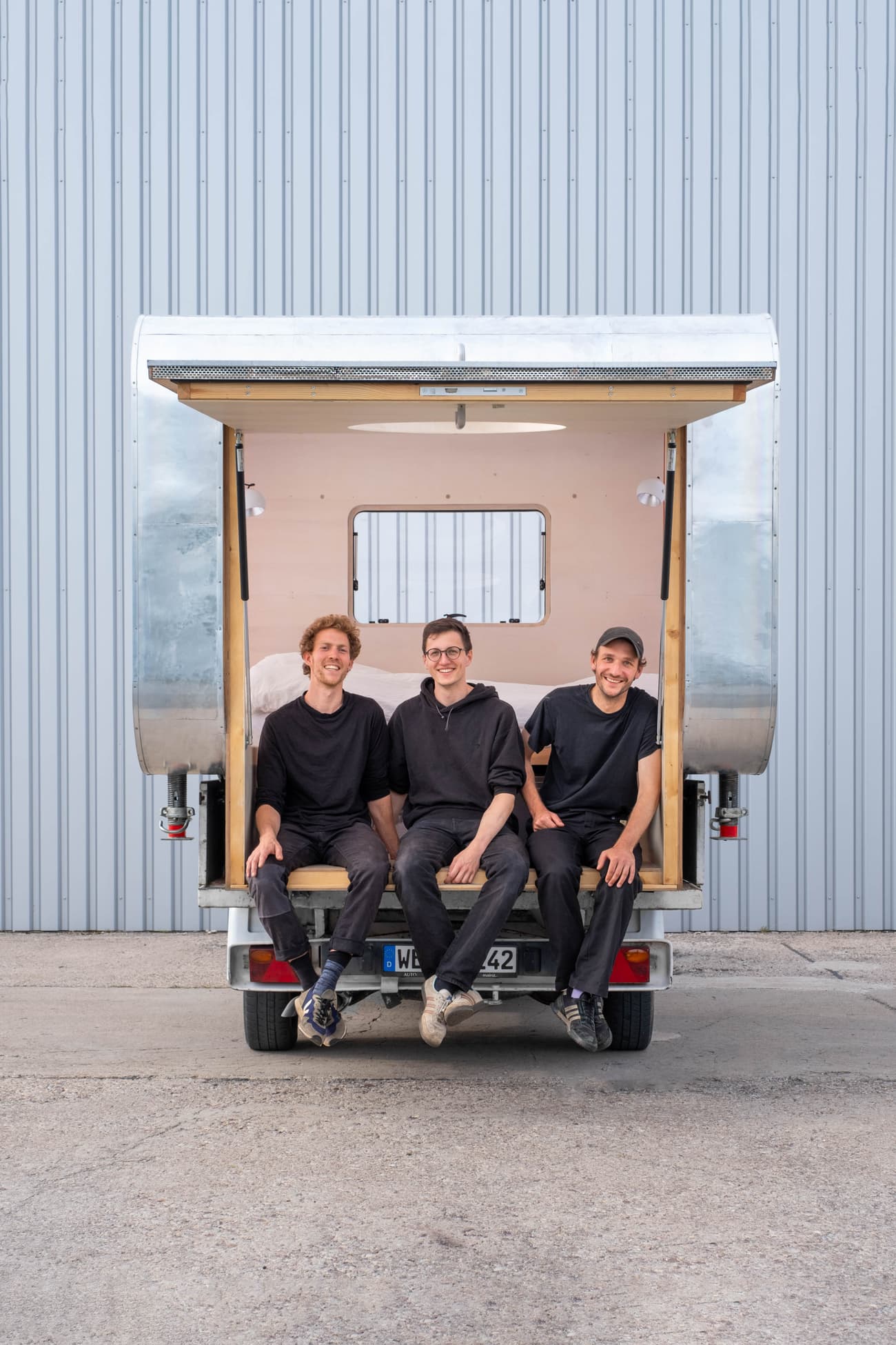 Architectural project - portable dwelling, tiny house, flexible living, micro home, transportable home, modern caravan, silver, camper, mobile living, metal siding, metallic finish, open hatch, wooden support, mobile design, urban camping, grey facade, multitasking space, tiny home movement, traveler living, travel trailer, urban lifestyle, grey, outdoor living, modular design, innovative design, lightweight design, functional space, adaptable design, light wood, functional design, eco friendly, Scandinavian influence, minimalist vibe, minimalist design, industrial chic, wood accents, compact design, custom build, compact living, sustainable living, minimalism, versatile space