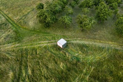 Architectural project - untouched nature, harmony with nature, self-sufficient, site-specific, tiny house, grass, small cabin, micro dwelling, white cube, cubic shelter, isolated home, grassy fields, pastoral view, secluded spot, tranquil scene, modern shelter, outdoor solitude, peaceful environment, temporary shelter, stark contrast, minimal design, eco-friendly design, passive design, eco design, green, rural architecture, minimalist retreat, minimalist style, lightweight materials, lightweight structure, geometric design, green landscape, white, energy efficient, simple living, rural setting, countryside, nature escape, off-grid living, compact living, environmental harmony, natural surroundings, simple form, sustainable living, meadow
