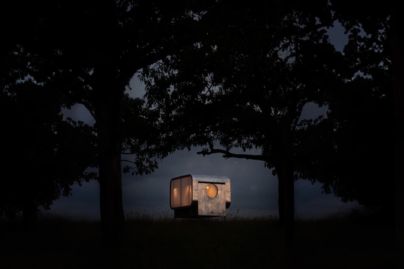 Architectural project - mobile home, portable home, prefab house, small house, night scene, dark ambiance, glazed facade, circle window, warm glow, architectural pod, design capsule, night view, silhouettes, unique structure, innovation, standalone house, minimal intervention, tiny architecture, dark, circular window, intimate space, soft lighting, serene environment, steel, shadow play, outdoor living, sustainable design, glass, neutral tones, brown, passive house, modular home, eco friendly home, cozy vibe, forest setting, nature retreat, nature integration, off-grid living, minimalist cabin, green design, forest shelter, surrounding trees, reflective surface, secluded home, low impact, warm lighting, architectural expression, modern cabin, minimalism, tranquility, efficient design, compact dwelling, small footprint, tiny home