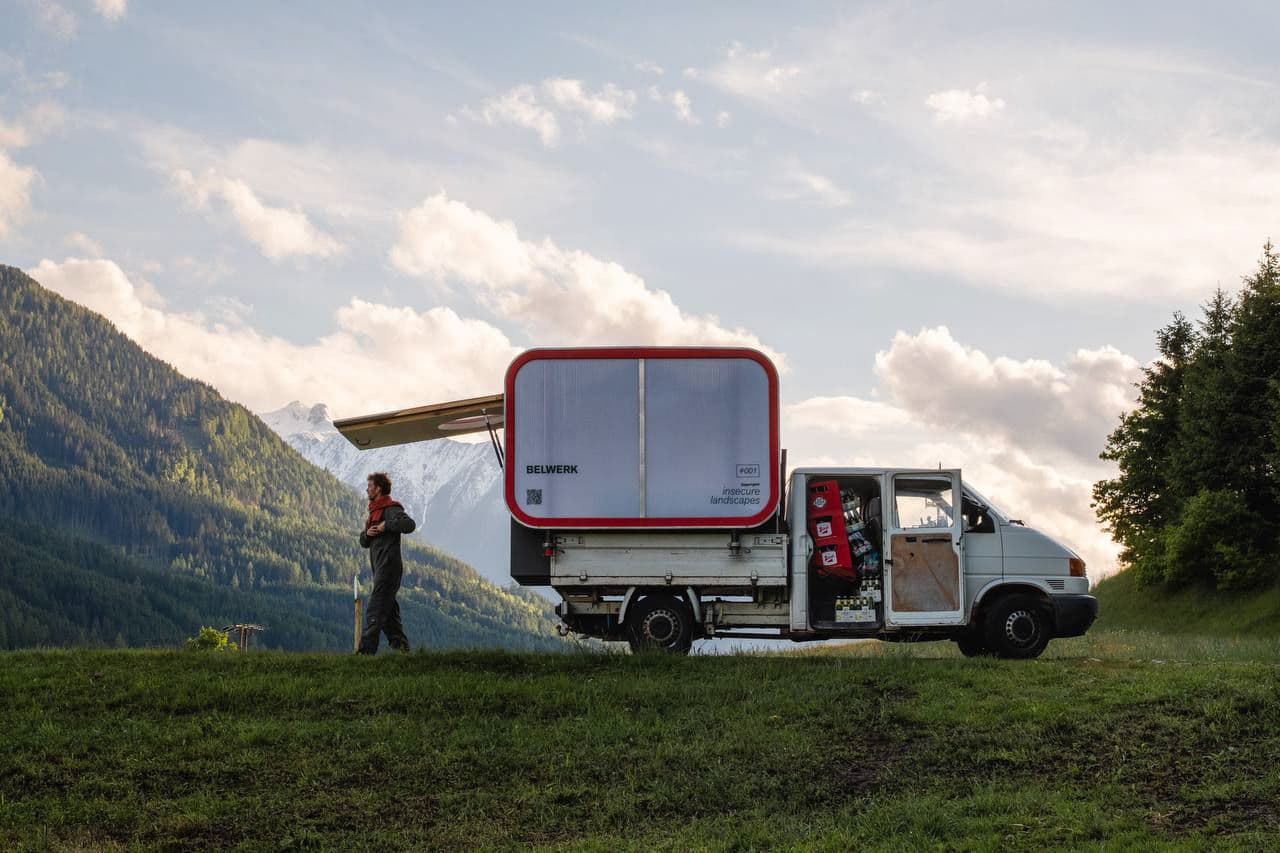 Architectural project - camper van, mobile home, adventure vehicle, tiny house, mountain view, scenic backdrop, travel life, minimalist travel, nomadic lifestyle, off-grid, portable home, eco travel, modern camper, modern nomad, flexible living, mountain retreat, getaway, adventure style, travel lifestyle, open road, road trip, nature vibes, scenic drive, wanderlust, remote living, off-the-grid, tiny space, multifunctional design, minimalist lifestyle, travel freedom, modular living, nature lover, grass, sky, clouds, minimal design, grey, outdoor living, sustainable design, eco design, innovative design, green, functional space, blue, lightweight structure, white, nature escape, green design, compact living, trees, sustainable living, versatile space, red
