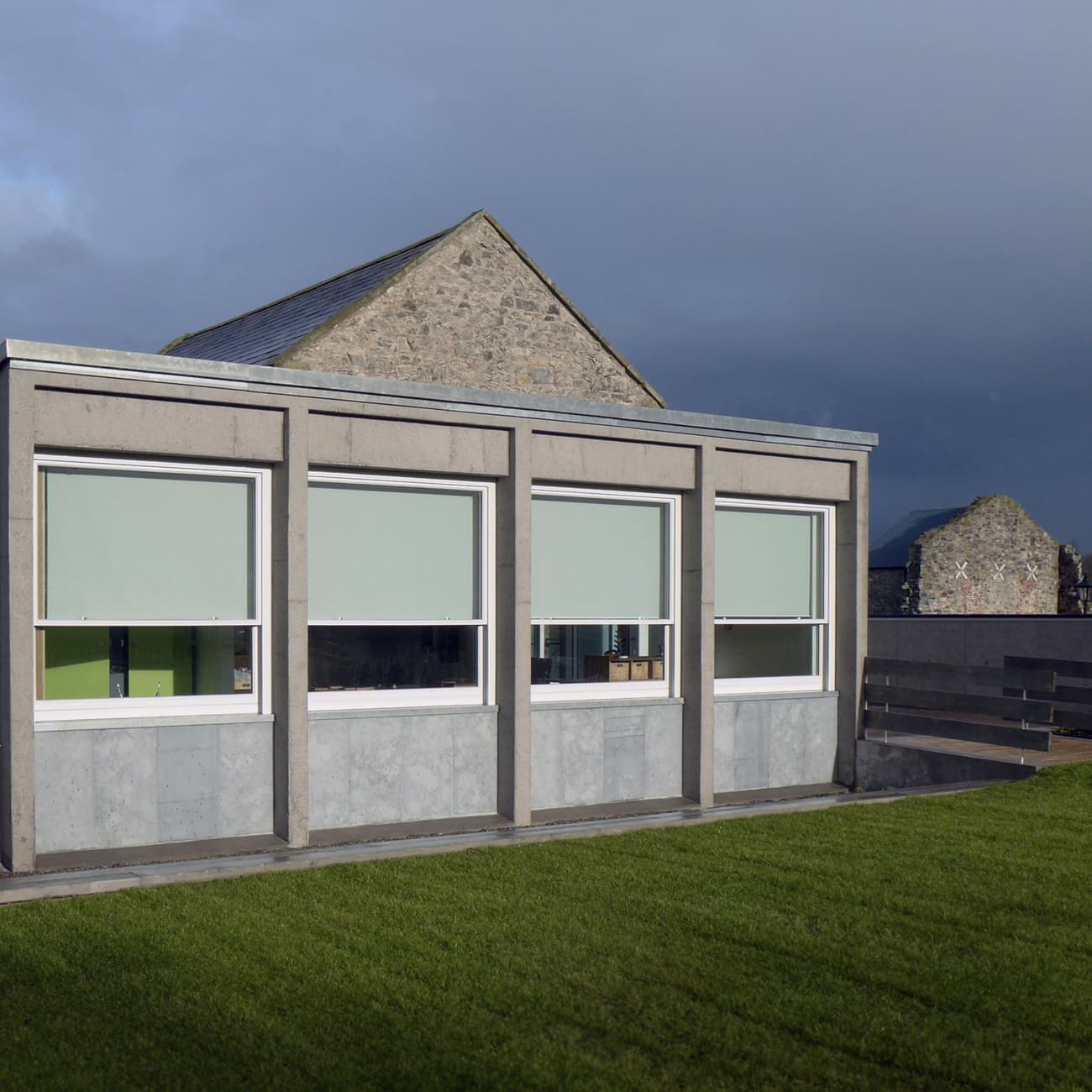 Architectural project - rectangular shape, grey facade, modern renovation, educational facility, concrete facade, stone building, utilitarian, concrete building, minimal design, outdoor space, natural light, passive design, eco design, sustainable construction, community space, grey, green, concrete, minimalist facade, low carbon design, functional design, daylight optimization, flat roof, contemporary design, green architecture, modern facade, clean lines, large windows, energy efficient, stone, stone wall, school building, educational building, school renovation, green space, educational architecture, outdoor learning, schoolyard, modern school, simple form, school architecture, practical design, lawn area