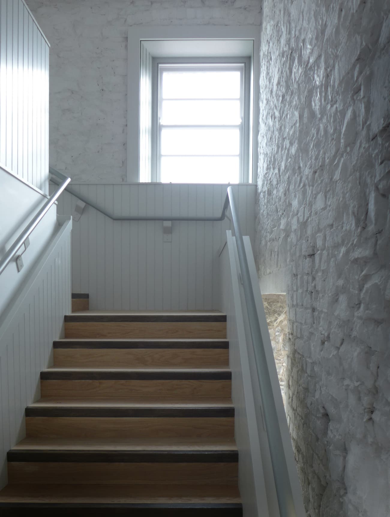 Architectural project - textured surfaces, light grey, brick wall, cozy ambiance, transitional space, homely feel, Scandinavian touch, timeless style, wooden steps, classic design, wood stairs, multi-level, stair railing, residential stair, serene vibe, architectural detail, eco-friendly design, natural light, grey, neutral tones, daylight, light wood, rustic charm, calming space, clean aesthetic, modern rustic, sustainable home, white walls, elegant design, white, textured wall, energy efficient, stone wall, traditional style, bright space, home design, airy atmosphere, interior design, simple lines, smooth finish, staircase, timber steps, stairwell