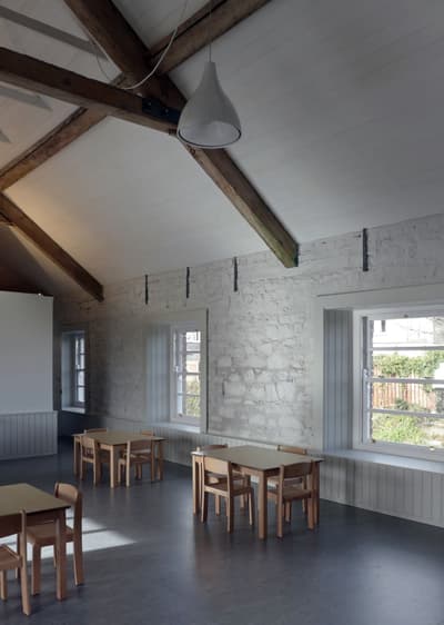 Architectural project - stone walls, modular furniture, meeting space, inviting vibe, wood, timber, natural light, sustainable design, eco design, grey, neutral tones, exposed beams, daylight, wooden ceiling, beige, light wood, multifunctional space, rustic modern, calm ambiance, neutral palette, minimalist design, gathering area, community center, event space, eco-friendly materials, workshop area, modern rustic, passive house, white walls, white, Nordic style, stone, cozy atmosphere, textured walls, Scandinavian design, educational space, simple furniture, pendant lamp, family-friendly, high ceiling, pitched ceiling