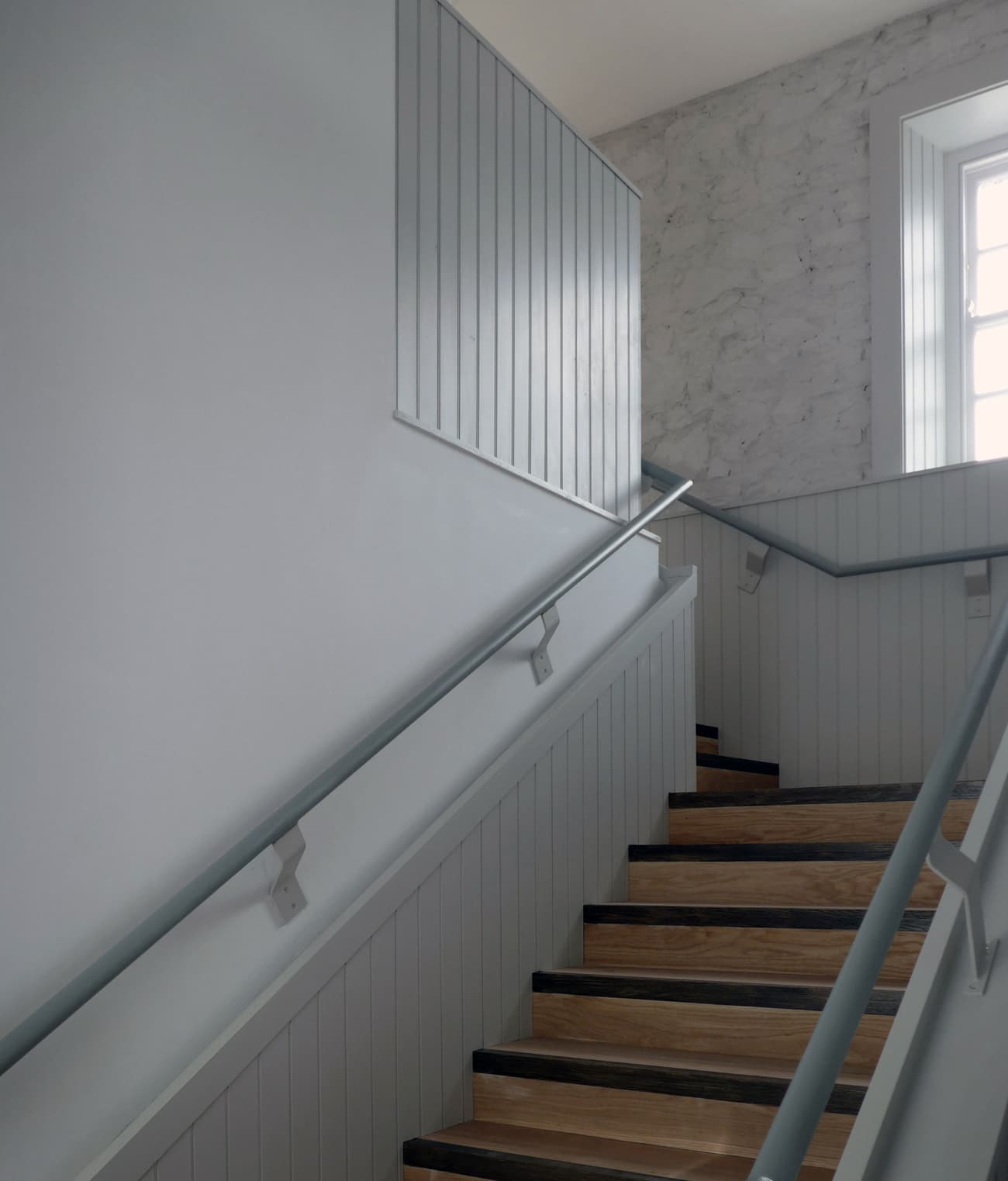 Architectural project - interior stair, home entry, refined design, handrail, residential stair, wood, timber, grey tones, natural light, grey, neutral tones, daylight, functional design, compact space, simple design, calming interior, Scandinavian style, neutral colors, light tones, contemporary home, white, Nordic design, textured wall, stone, stone wall, timber panel, modern home, vertical panels, clean design, wood panel, Japandi style, minimalist interior, staircase, timber steps