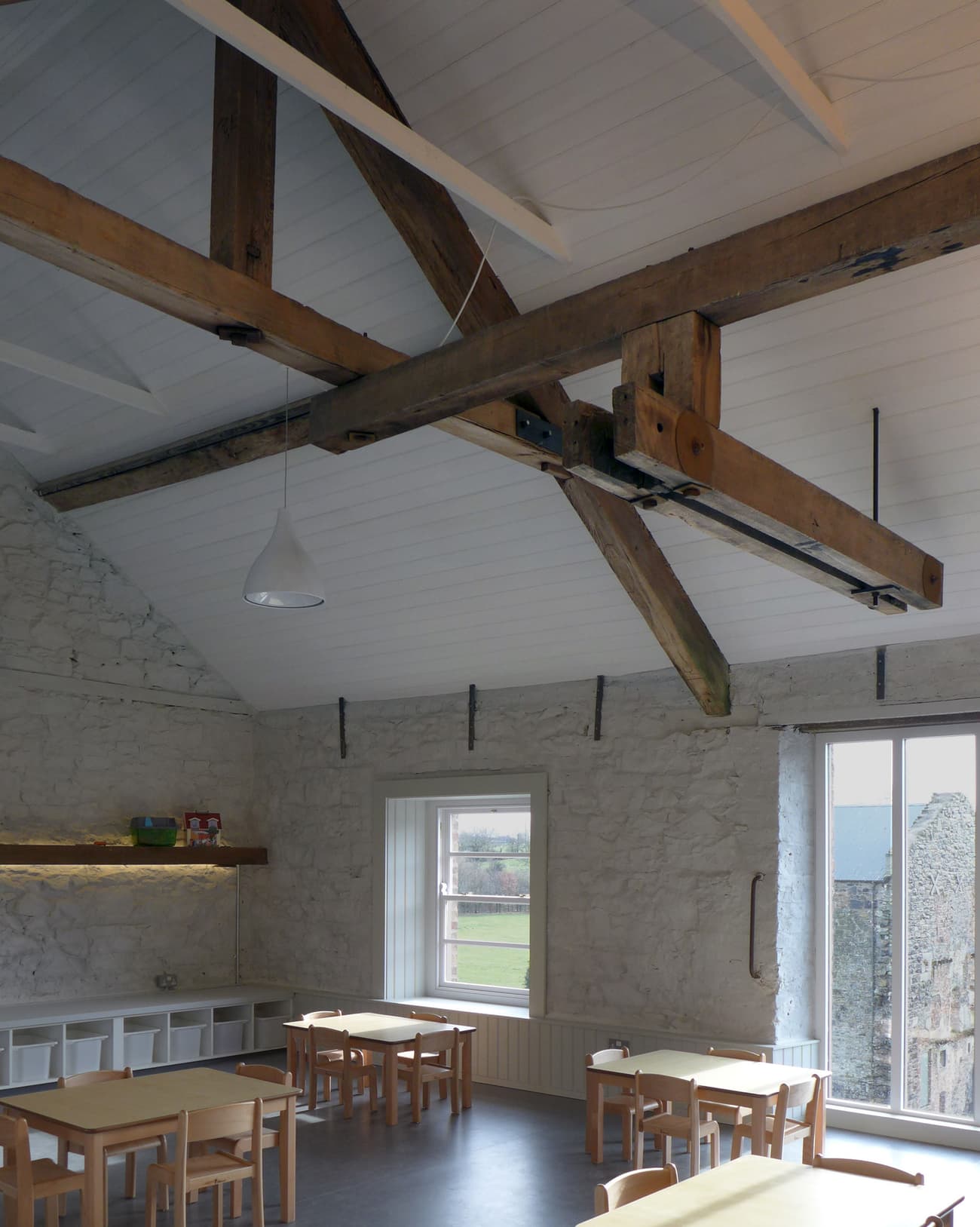 Architectural project - light grey, sustainable space, stone walls, home dining, cozy dining, vintage vibe, Scandinavian touch, rustic dining, minimalist furniture, barn conversion, simple chairs, open beams, relaxed dining, warm interior, natural materials, wood, timber, natural light, warm tones, eco design, neutral tones, exposed beams, wooden ceiling, beige, light wood, wooden beams, farmhouse style, timber beams, rustic charm, white, cozy vibe, Nordic style, large window, stone, plaster, timber ceiling, countryside view, family space, dining area, inviting space, casual dining, traditional design, heritage building, textured walls, rural charm, nordic influence, open view