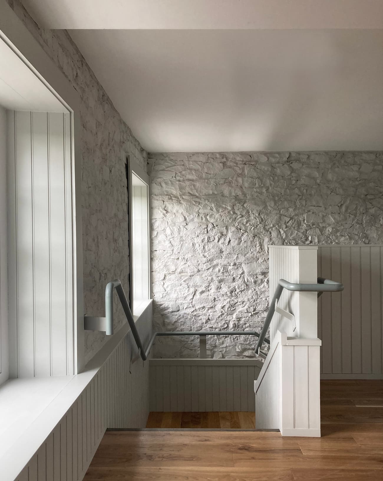 Architectural project - transitional space, interior window, refined finish, rustic hallway, heritage style, classic design, handrail, European style, architectural detail, wood, timber, natural light, warm tones, grey, neutral tones, daylight, light wood, farmhouse style, simple design, rustic charm, serene atmosphere, timber floor, minimalist design, Scandinavian vibe, cozy space, warm wood, wood floor, clean lines, white walls, light filled, white, plaster, inviting space, Nordic vibe, traditional style, textured walls, wall texture, wood trim, bright interior, interior, plaster walls, hallway, modern hallway, stairwell