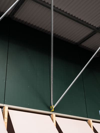 Architectural project - open ceiling, metal structure, construction elements, industrial interior, warehouse vibe, modern ceiling, dark green, ribbed ceiling, diagonal bracing, functional architecture, commercial building, utility elements, light support, structural art, steel tubing, modern warehouse, industrial look, engineering focus, exposed metal, industrial green, ribbed metal, minimalist colors, architectural detail, industrial design, raw materials, steel, metal, eco design, corrugated roof, industrial aesthetic, contemporary style, grey, exposed beams, structural design, functional design, steel framework, simple materials, industrial chic, sustainable building, structural integrity, minimalist space, open space, high ceiling, architectural geometry, green wall, exposed ceiling