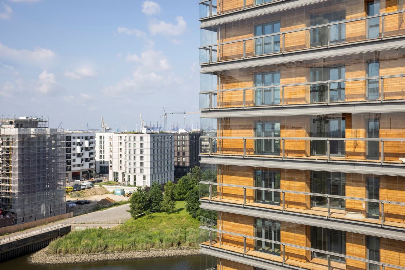 Architectural project - urban regeneration, river view, city view, high rise, building exterior, natural materials, wood elements, wood, timber, city living, steel, cityscape, sustainable design, glass, warm tones, modular construction, green building, contemporary architecture, urban landscape, grey, neutral tones, urban development, urban environment, beige, brown, wood facade, light wood, honey wood, urban community, timber architecture, modern facade, timber cladding, energy efficient, eco architecture, residential building, sleek design, modern living, glass facade, apartment building, efficient design, urban living, modern city