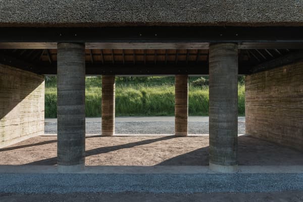 Architectural project - raw concrete, countryside vibe, earthy architecture, stone path, concrete columns, natural materials, raw materials, natural light, shadow play, passive design, sustainable design, warm tones, eco design, open structure, rural architecture, vernacular architecture, natural textures, outdoor pavilion, rammed earth, earth tones, earth construction, landscape integration, harmonious design, stone, open plan, shelter design, environmental design, rustic architecture, eco-friendly structure, rural setting, textured walls, natural ambiance, green design, pavilion design, open air, minimalist aesthetic, brown tones