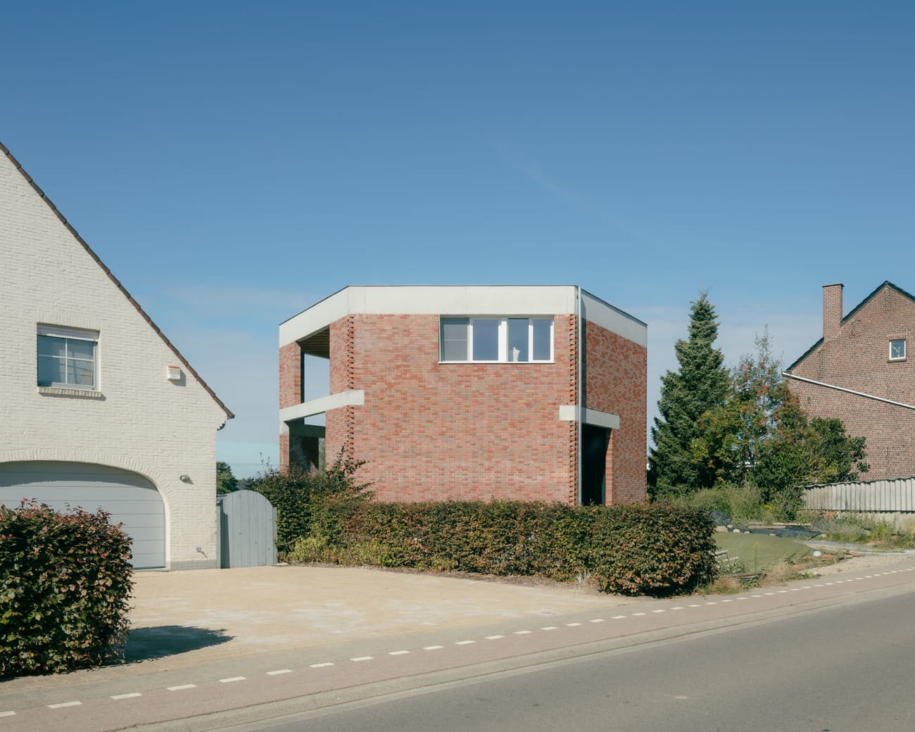 Architectural project - minimalist home, cubic form, brick house, architectural symmetry, driveway, neighborhood setting, suburban setting, natural light, sustainable design, contemporary architecture, neutral tones, concrete, exterior design, flat roof, minimalist style, neutral palette, minimalist design, eco-friendly materials, blue sky, geometric design, sustainable home, contemporary home, modern facade, clean lines, large windows, energy efficient design, white, simple facade, brick, red brick, residential architecture, residential home, modern home, sleek design, modern living, facade design, modern exterior, simple architecture, modernist influence, urban home, suburban house, brick texture, red