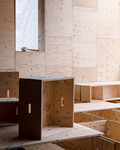 Architectural project - thoughtful design, plywood walls, plywood texture, simple seating, wooden box, crafted space, modular seating, timber furniture, box seating, plywood furniture, crate chair, versatility, plywood construction, sustainable furniture, wooden box seat, warm interior, indoor space, natural materials, raw materials, natural light, sustainable design, warm tones, innovative design, architectural installation, daylight, light wood, functional design, eco friendly, contemporary design, Scandinavian style, neutral palette, minimalist design, eco materials, multifunctional, modern aesthetics, creative space, timber walls, architectural details, timber interior, inviting space, cozy atmosphere, wooden elements, modern style, artistic space, wood interior