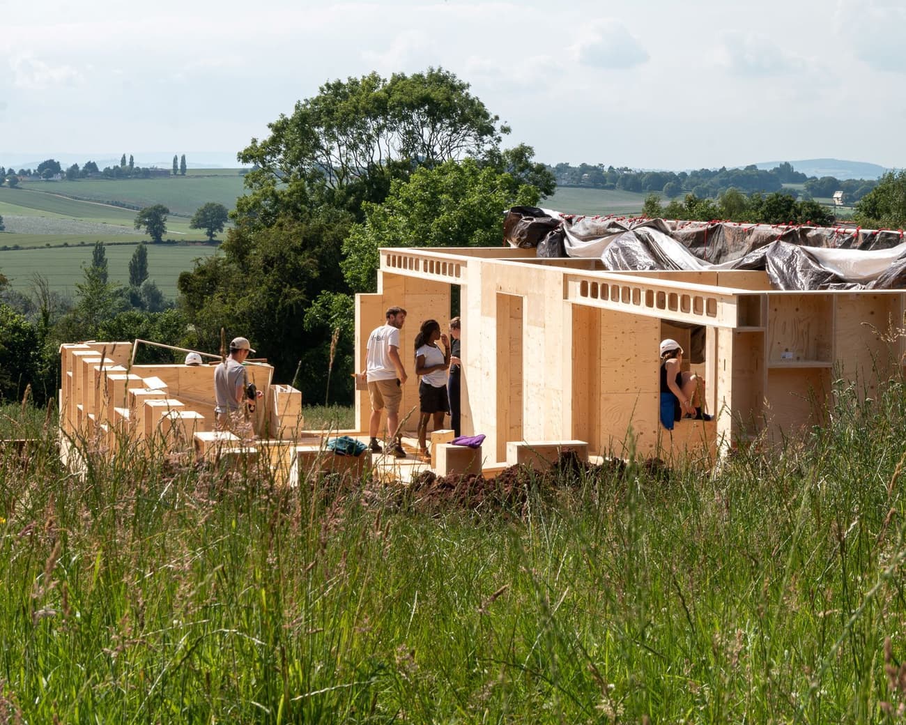 Architectural project - bio-based materials, scenic location, open field, open site, nature building, community build, self build, rural site, collaborative work, renewable resources, natural materials, sustainable materials, wood, timber, outdoor space, natural tones, sustainable construction, green building, simple structure, neutral tones, under construction, lightweight design, construction project, landscape architecture, beige, light wood, natural setting, timber construction, eco-friendly construction, building process, eco building, unfinished building, timber panels, timber walls, wood panels, rural construction, rural development, wood house, timber house, countryside view, off-grid living, nature friendly, wooden structure, wooden exterior, low impact design, participatory design, green field