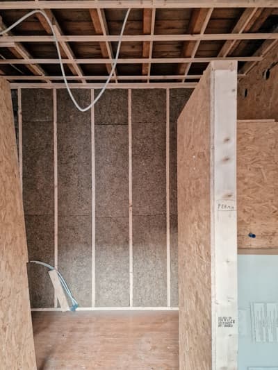 Architectural project - workshop vibe, raw aesthetic, industrial look, OSB panels, OSB, renovation project, exposed framing, ceiling structure, in-progress, insulation visible, space frame, unfinished walls, rustic construction, home build, natural materials, wood, timber, timber frame, warm tones, natural tones, modular design, eco design, simple structure, construction phase, under construction, functional space, plywood, building site, beige, brown, light wood, engineered wood, compact space, eco-friendly construction, construction details, building process, minimalist structure, wood structure, unfinished interior, sustainable building, plywood wall, structural wood, raw texture, wooden elements, wood ceiling, structural elements, practical design